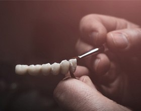 Lab technician holding replacement teeth