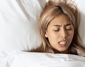 Woman grinding her teeth while asleep