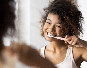 Woman brushing her teeth before dental checkup and teeth cleaning visit