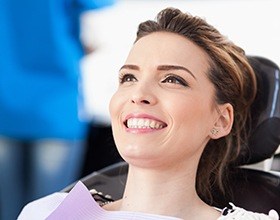 Woman smiling in dental chair after gum recontouring