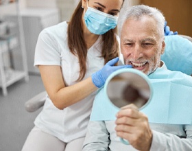 Man examining new dental bridge in Chesterfield with a dentist