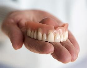 Closeup of someone holding a denture