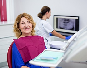 Woman smiling in dental chair for denture consultation