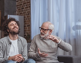 a mature man with dentures talking with another man