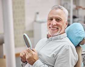 patient smiling while sitting in dental chair