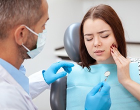 woman paying for the cost of emergency dentistry in Chesterfield