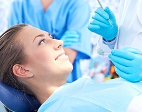 Relaxed woman smiling in dental chair after tooth extraction