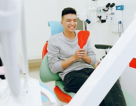Man in dentist’s chair looking in mirror