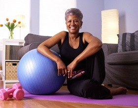 Smiling older woman with dental implant supported dentures prepared for workout