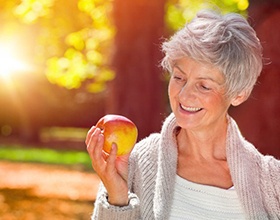 elderly woman holding an apple 