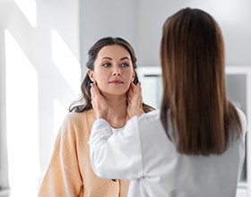 Medical professional touching patient’s lymph nodes