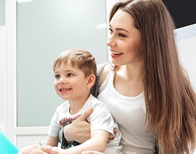 Mother holding child in lap at dentist