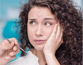 Woman in pain holding jaw before root canal therapy