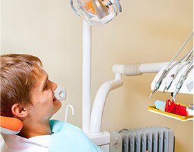 Smiling man in dental chair for tooth extraction
