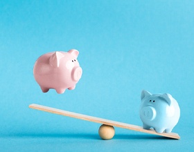 Piggy banks on balance scale