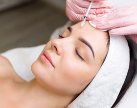 Woman receiving Xeomin injection between her eyebrows