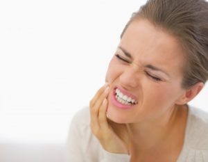 woman holding her jaw in pain