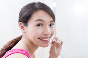 woman holding Invisalign tray