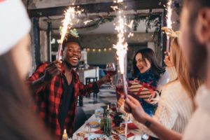 person holding a sparkler with their friends