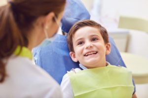 boy smiling sitting in children’s dentist chair