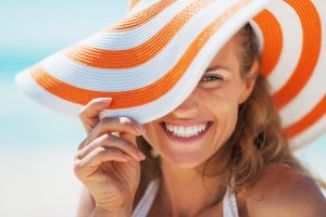 happy young woman in swimsuit and beach hat