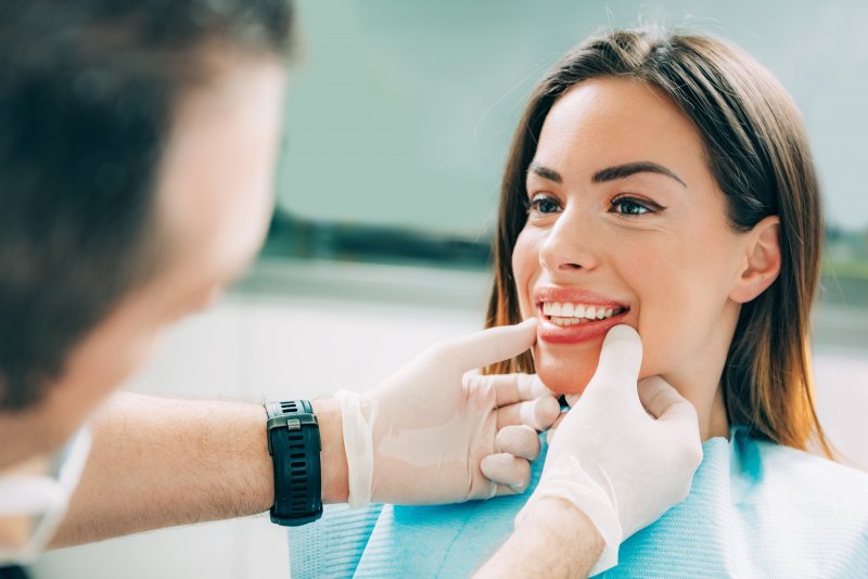 A dentist assessing his patient’s smile